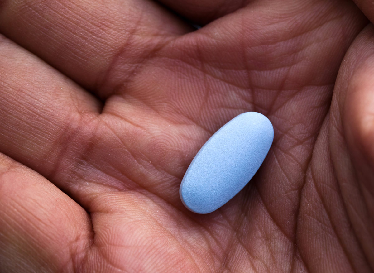 Close-up photo of a blue PrEP pill in someone's hand
